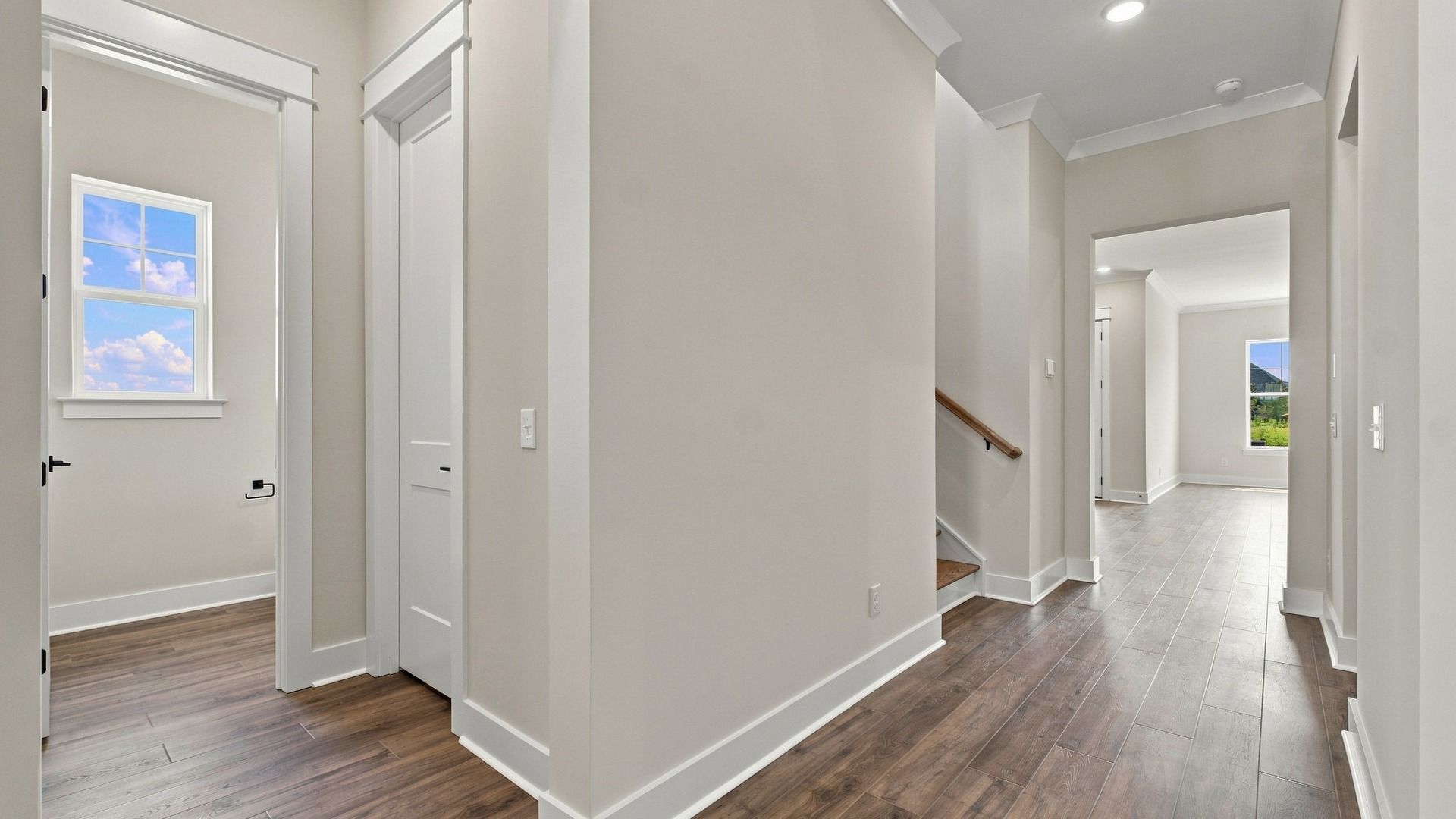 Hallway view of guest/ half bathroom entrance next to stairs.