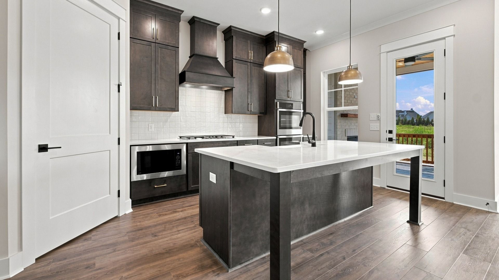 Gorgeous modern kitchen with dark wood cabinets and island with spacious pantry.