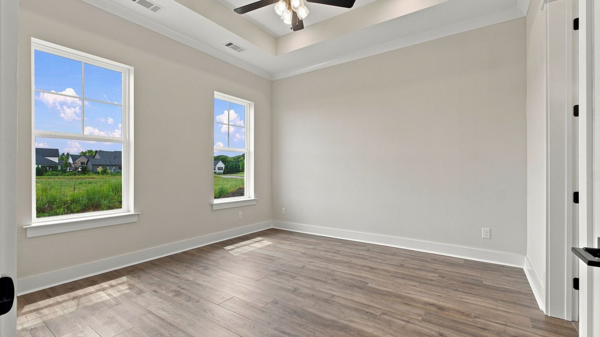 Upstairs room with two windows and ceiling fan and connected bathroom and walk-in closet.