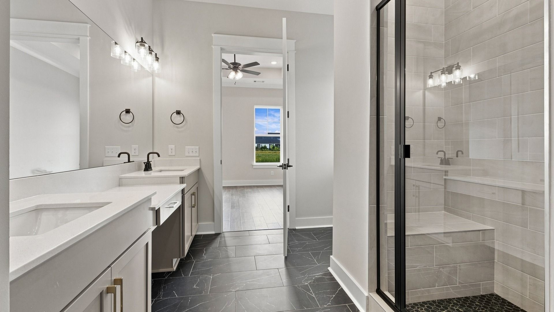Closet view of bathroom showing spacious walk-in shower and dual sinks.