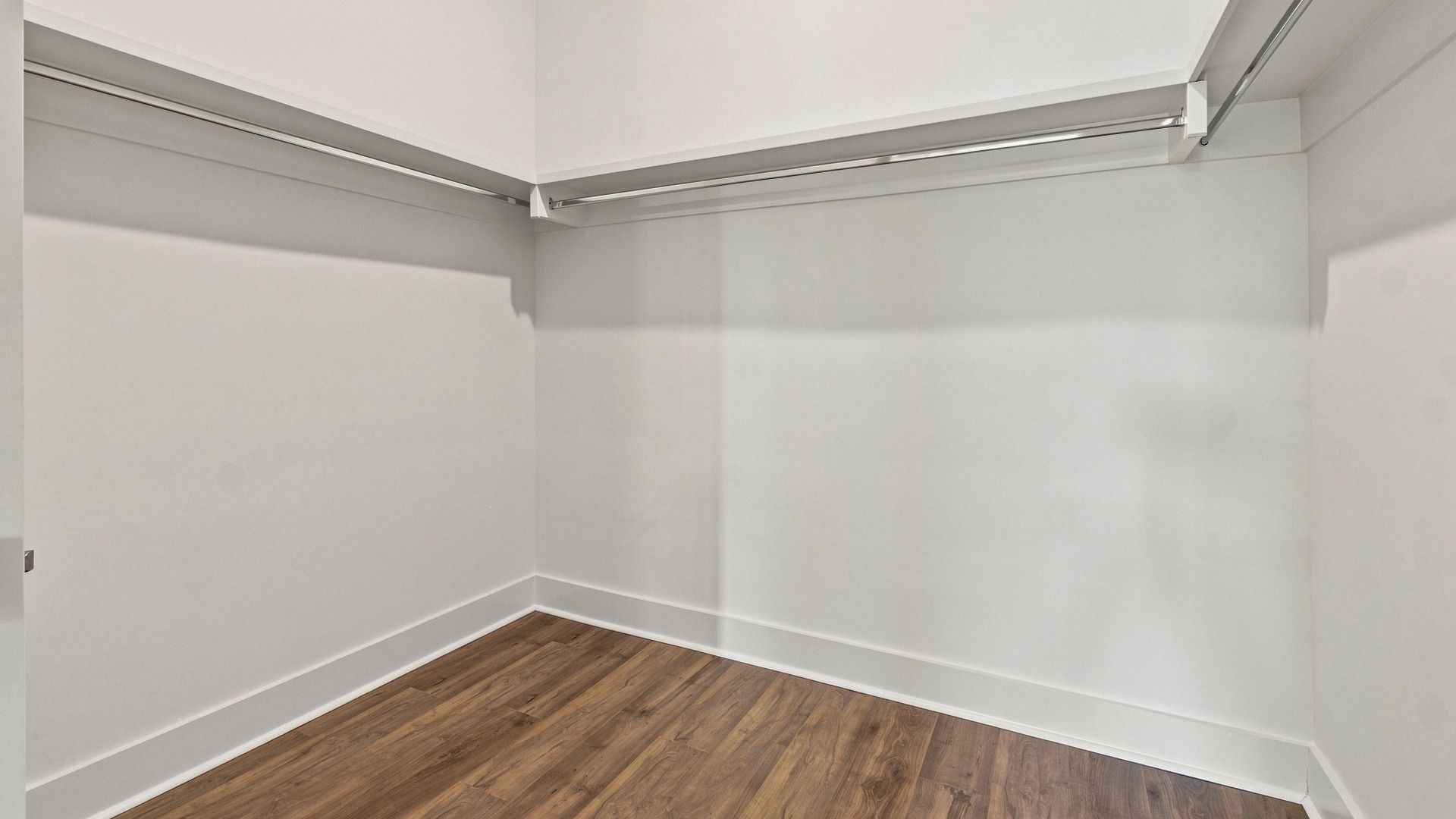 Spacious walk-in closet with wood flooring and storage options.