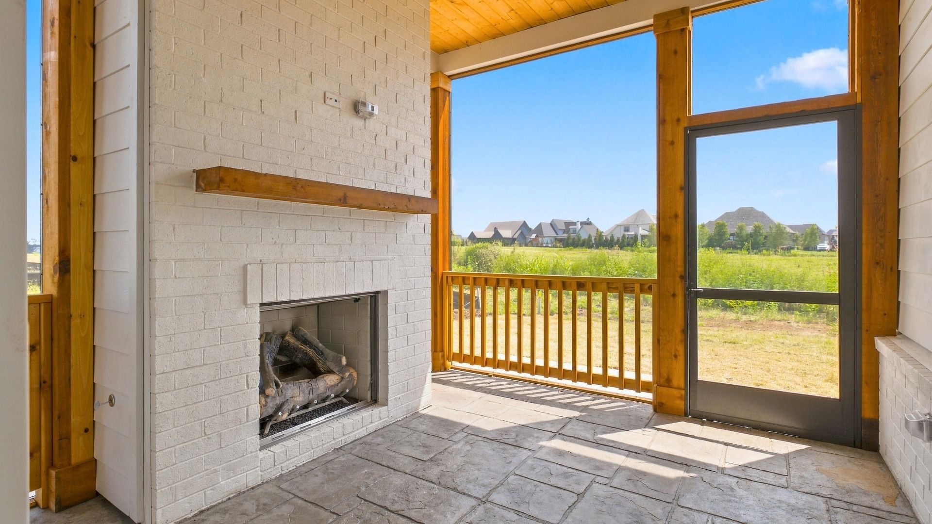 Screened-in backyard porch living area with fireplace allowing for outdoor activities.