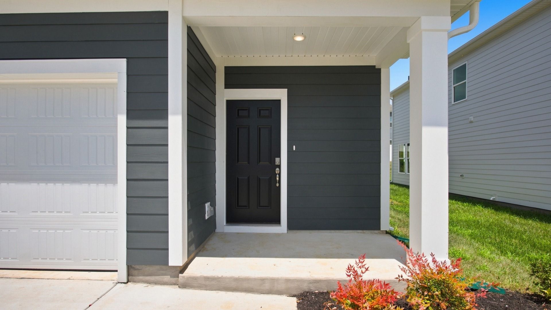 Closer view of front porch with charming black front door