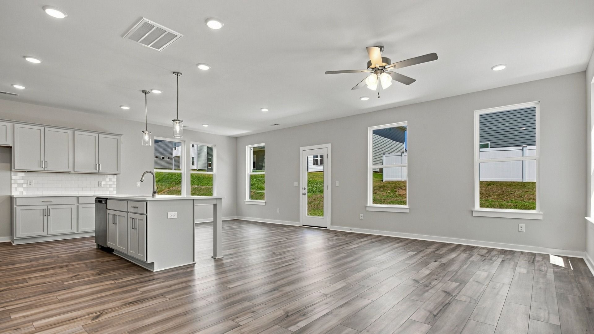 Elevated kitchen with various windows, island, ceiling fan, and other kitchen essentials