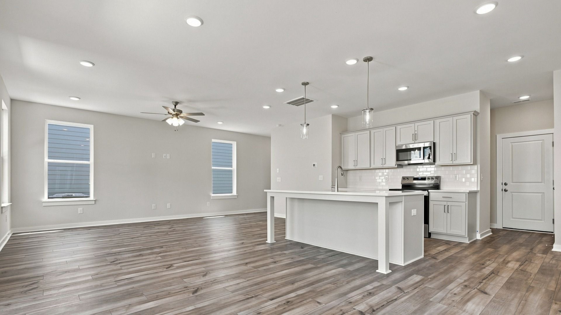 Angled view of kitchen from backyard door showing pantry door alongside convenient cabinet space