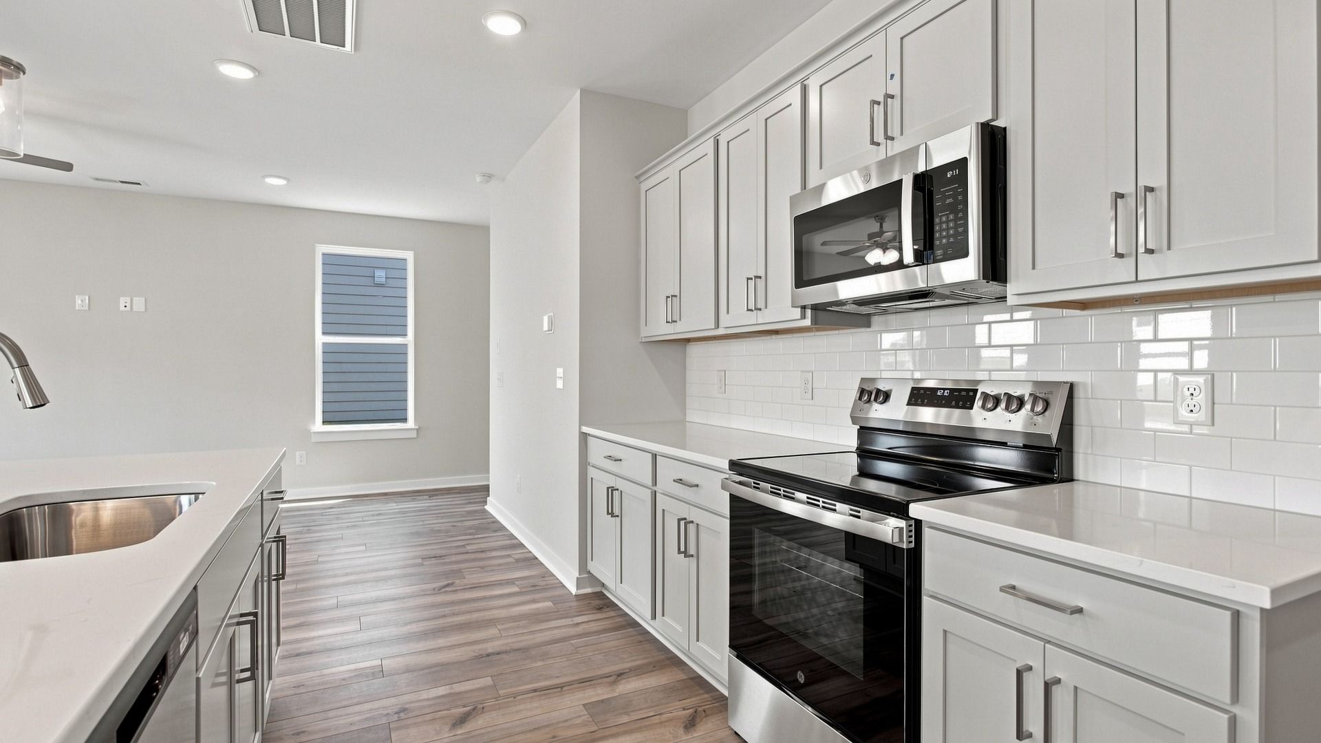 Countertop space combined with oven and microwave across from island with sink