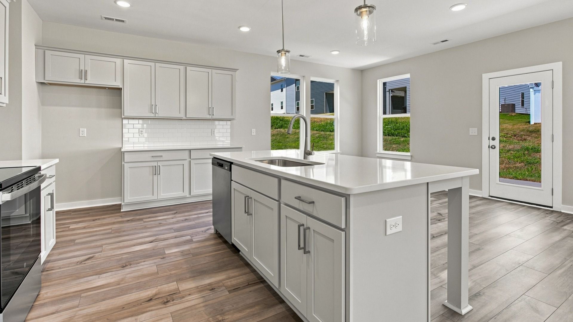 Closer view of elevated kitchen island with cabinet space alongside sink and dishwasher