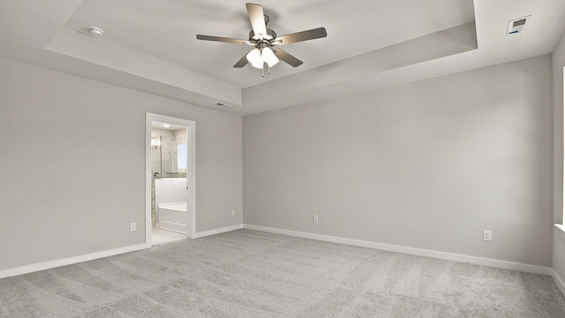 Spacious primary bedroom with tray ceilings for a lavish feeling