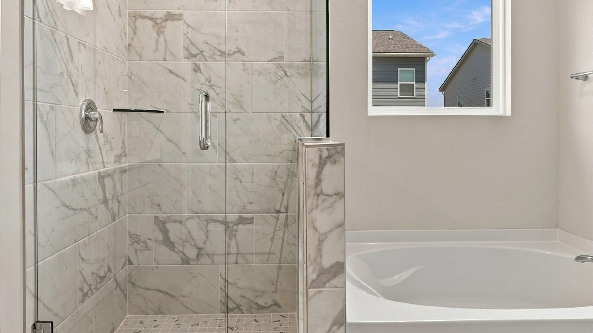 Tiled shower and separate soaking tub in primary suite