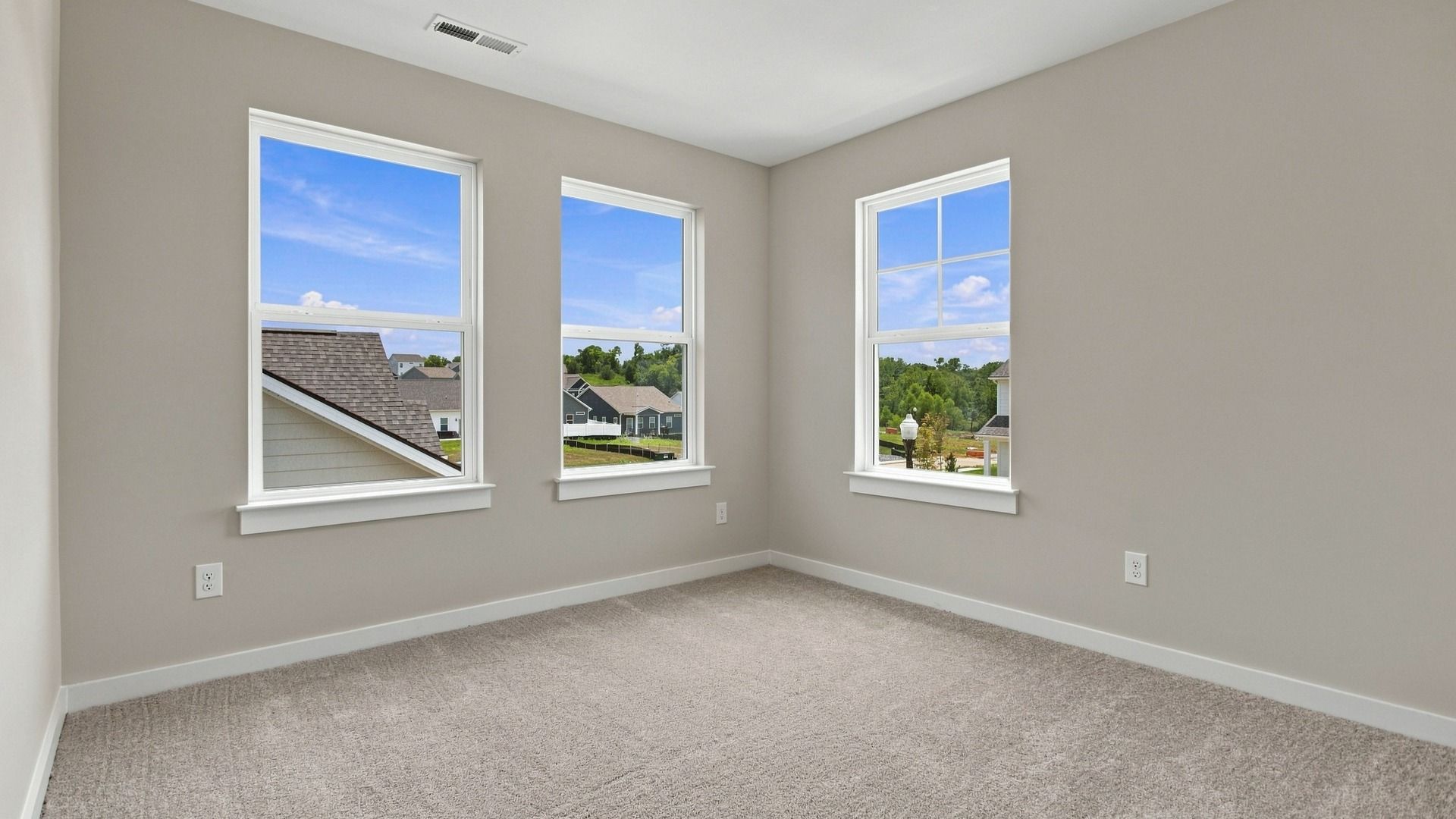 Upstairs secondary room with three windows showcasing community view