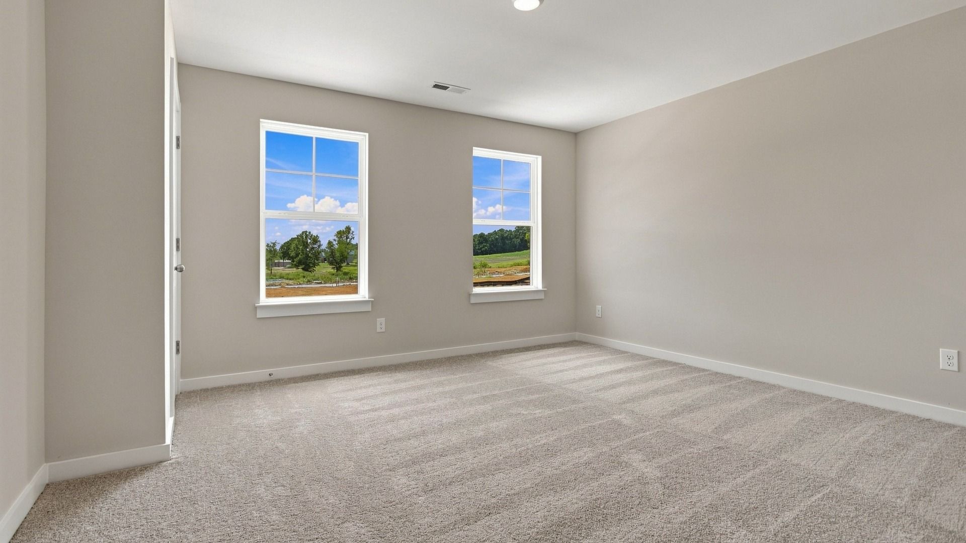 Other secondary bedroom with wall space and two windows next to closet
