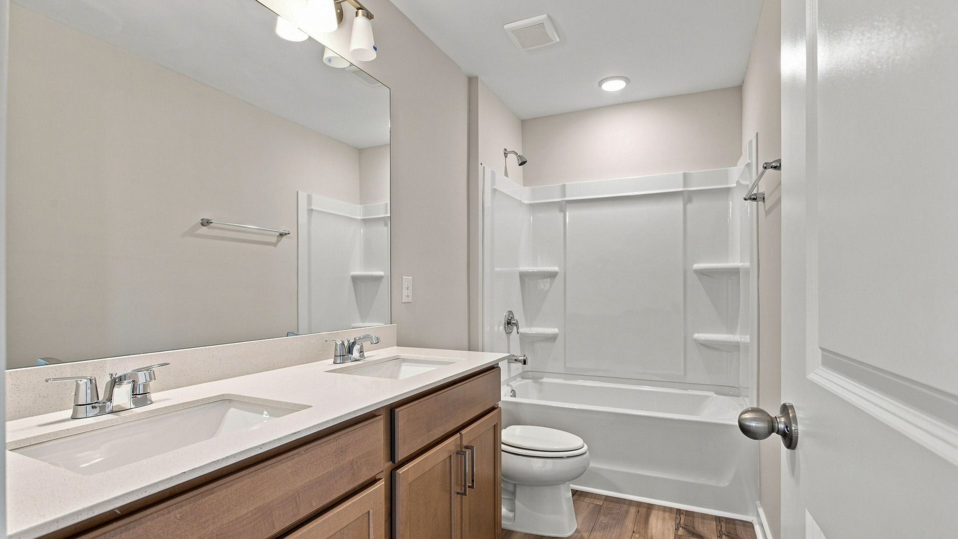 Secondary bathroom with elevated designs of dual vanities paired with spacious bath and shower.