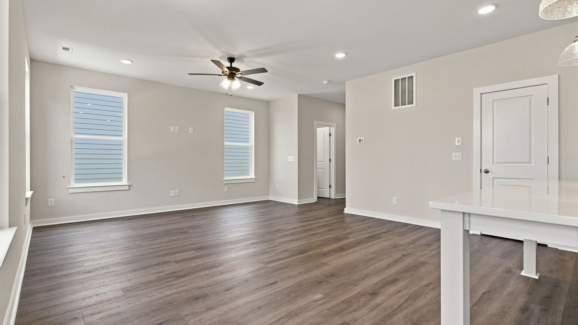 View from kitchen of living space filled with natural lighting from various windows