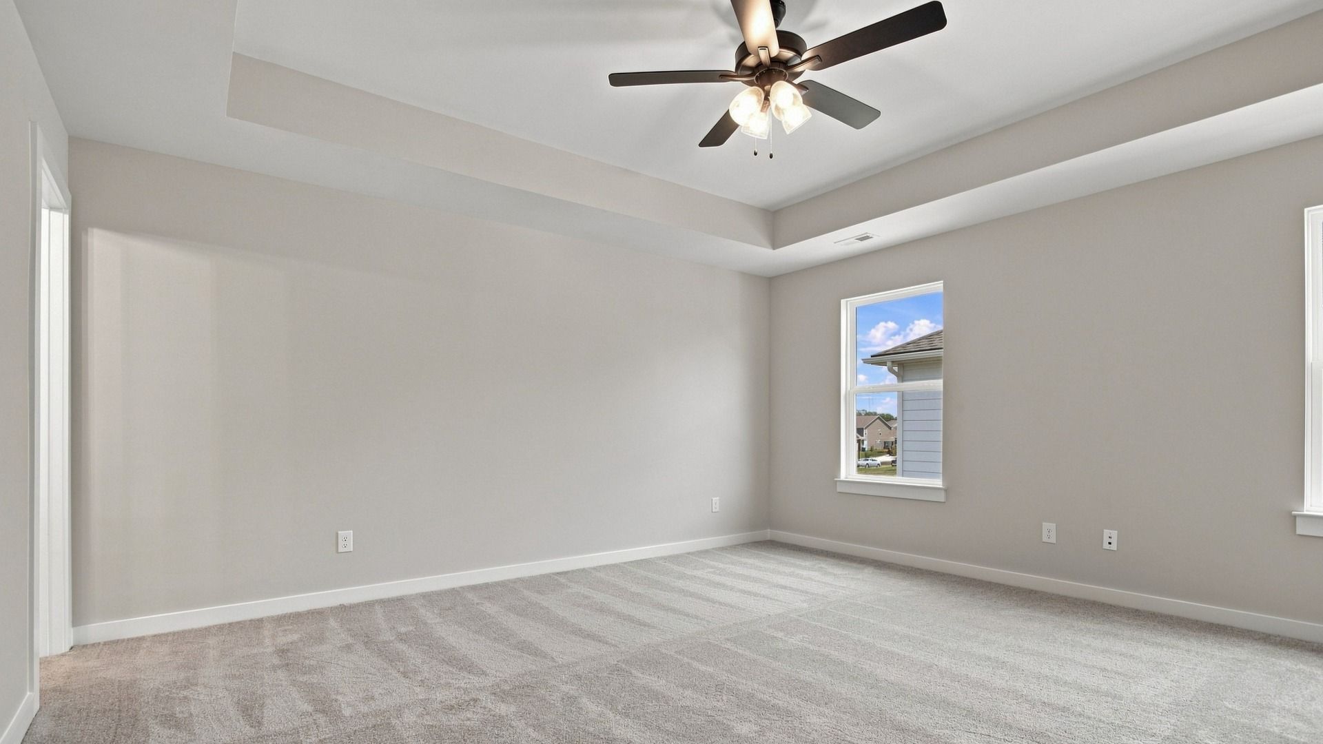 Angled shot of primary bedroom with window sights of community from upstairs