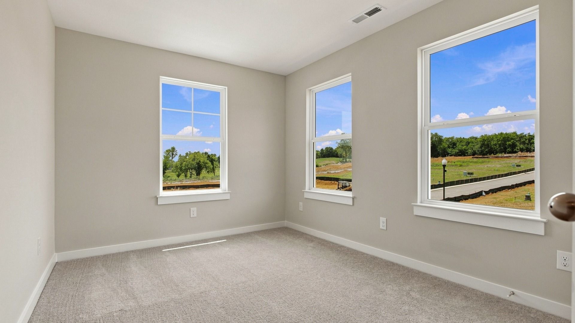 Separate spacious secondary bedroom with three windows and pleasant view of the community