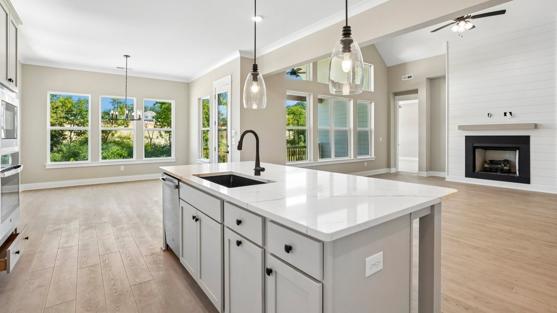 Hanging lights over elevated kitchen island with sink and dishwasher