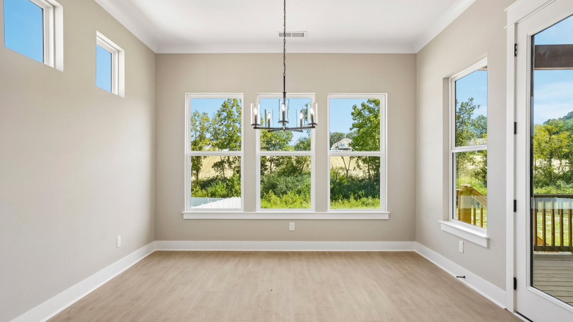 Ding areas with various windows and hanging light next to backyard door