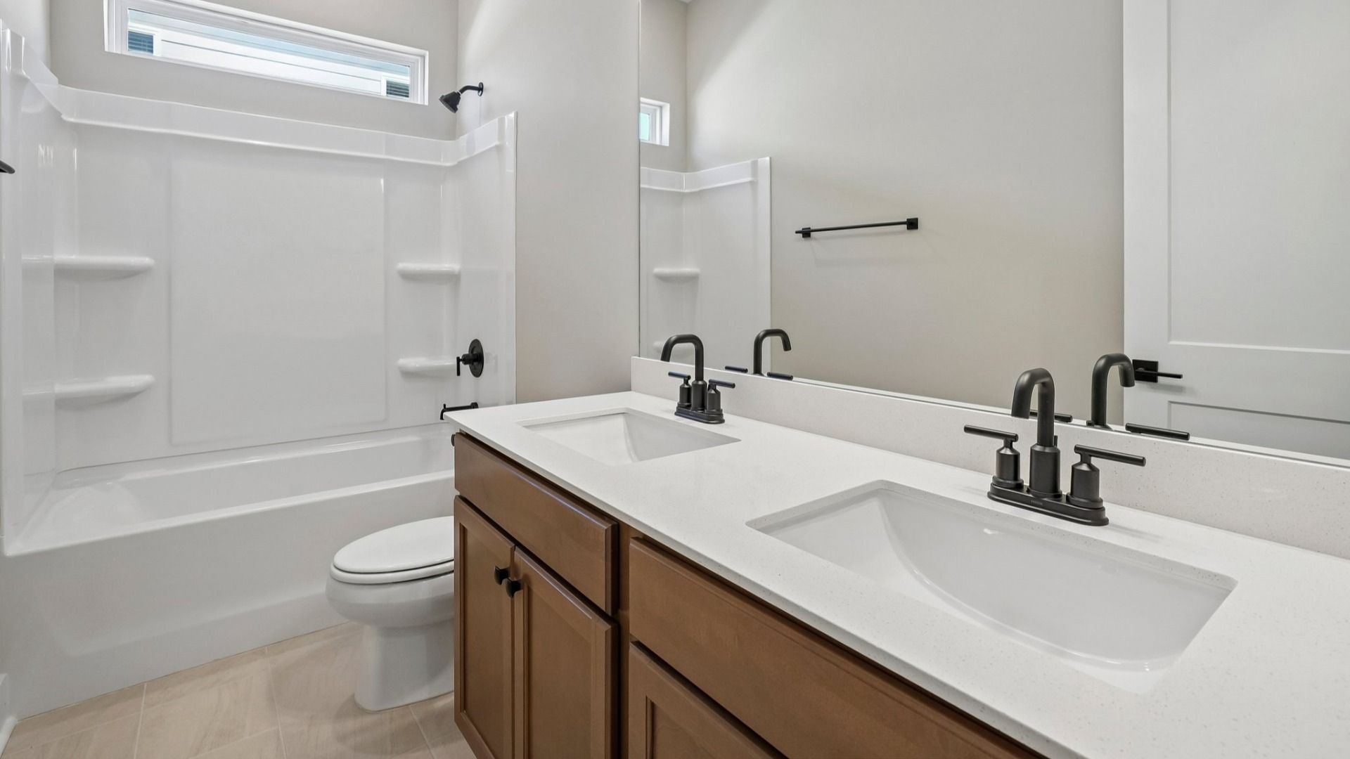 Secondary bathroom with elevated dual vanities and bath