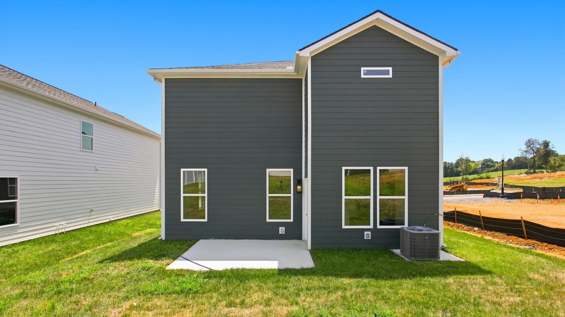 Exterior of two story home with blue siding and concrete patio