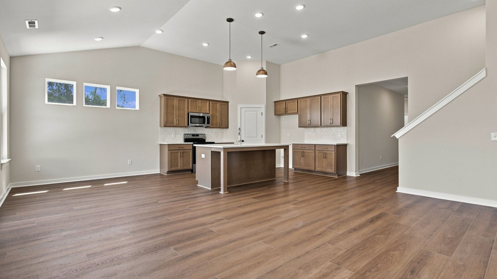 Open concept first floor with hard-surface flooring throughout the kitchen, dining, and living room areas