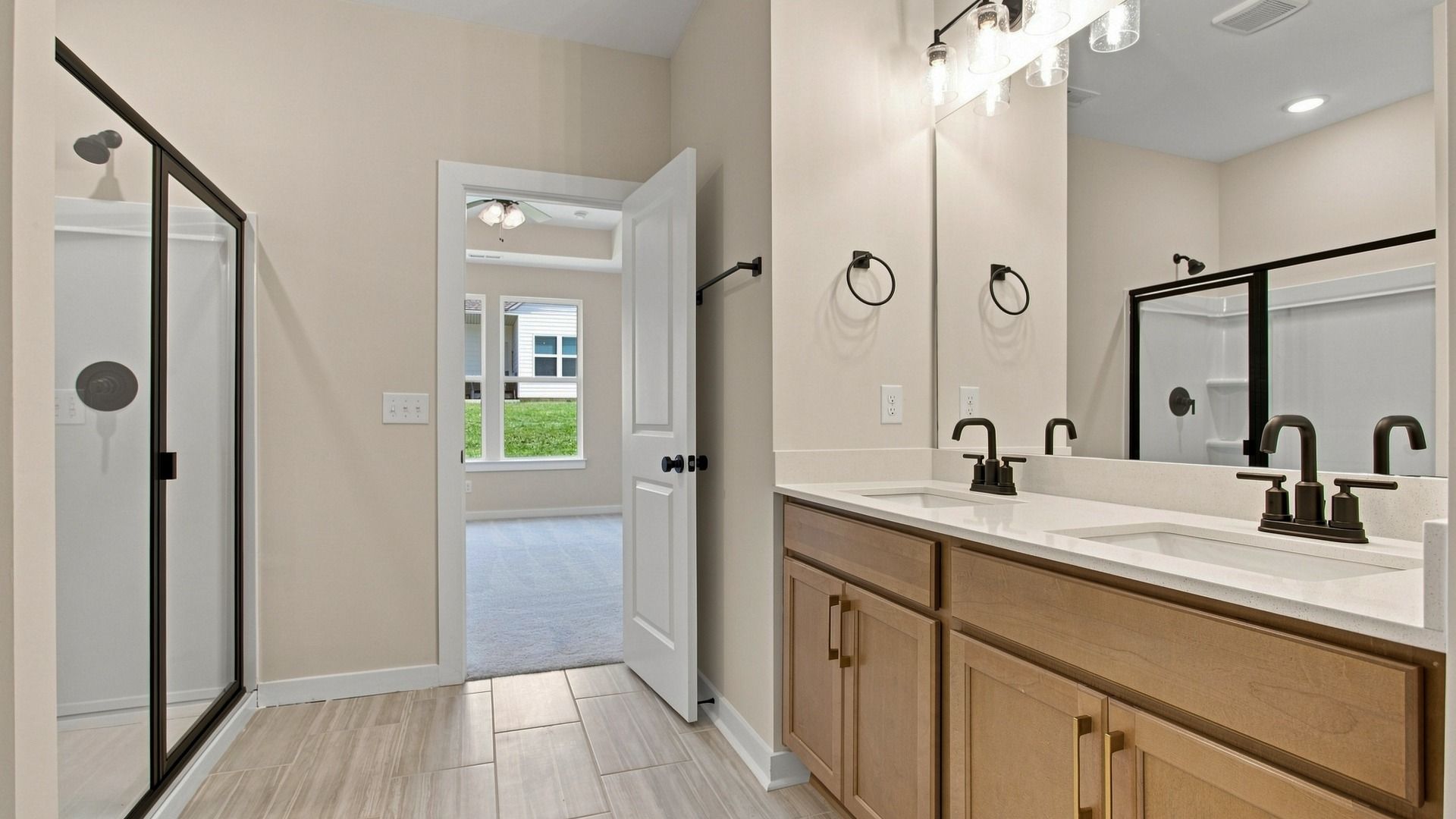 Primary bathroom with dual vanity, shower, storage, and walk-in closet