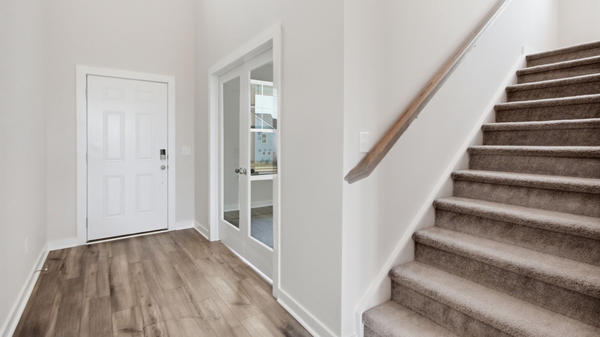 View of front entrance and versatile room from staircase