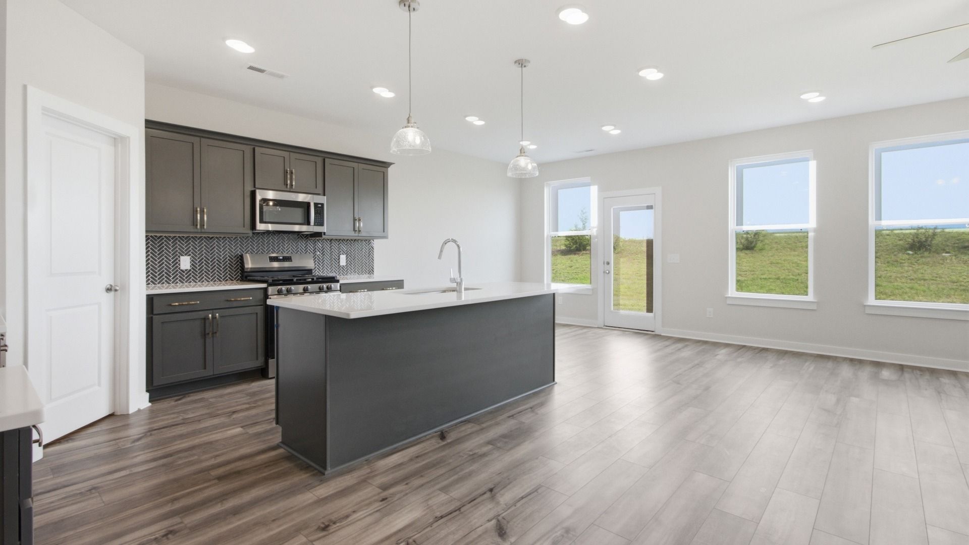 Spacious kitchen with island and dining spaces next to windows