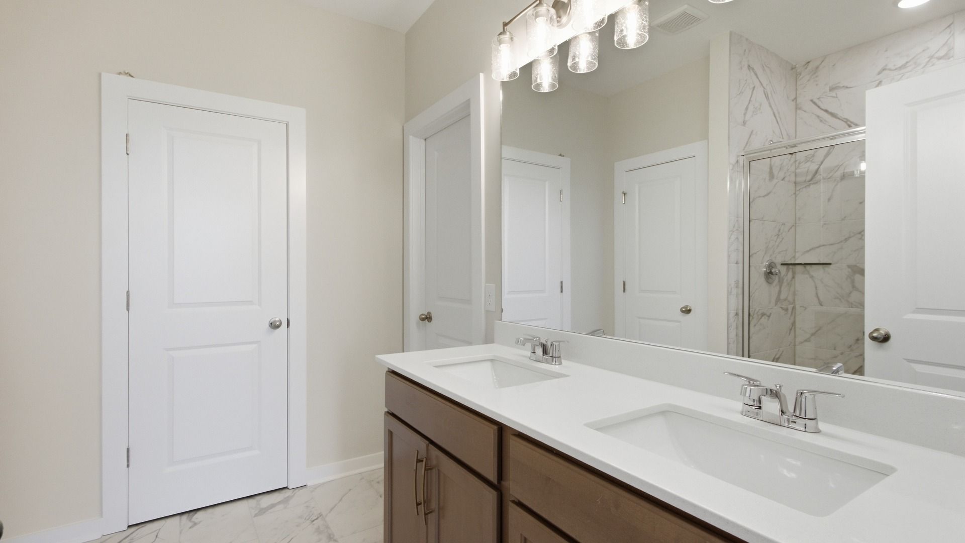 Primary bathroom with sizeable mirror and dual vanities