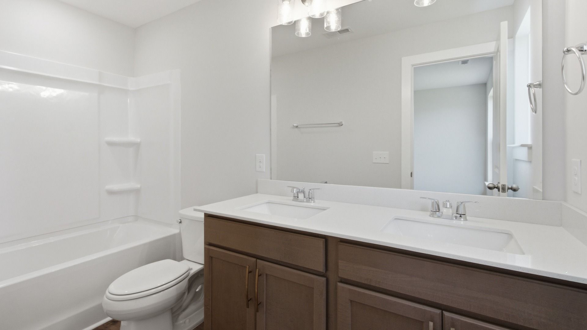 Secondary bathroom with elevated finishes such as dual vanities and bathtub