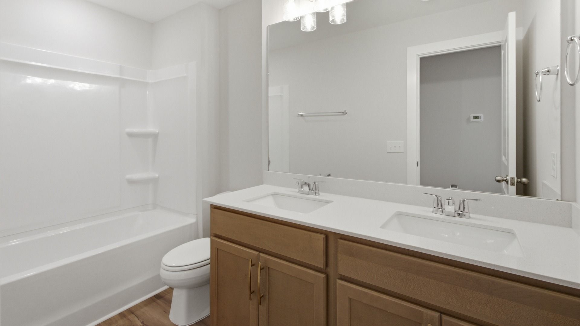 Secondary bathroom with elevated finishes such as dual vanities and bathtub