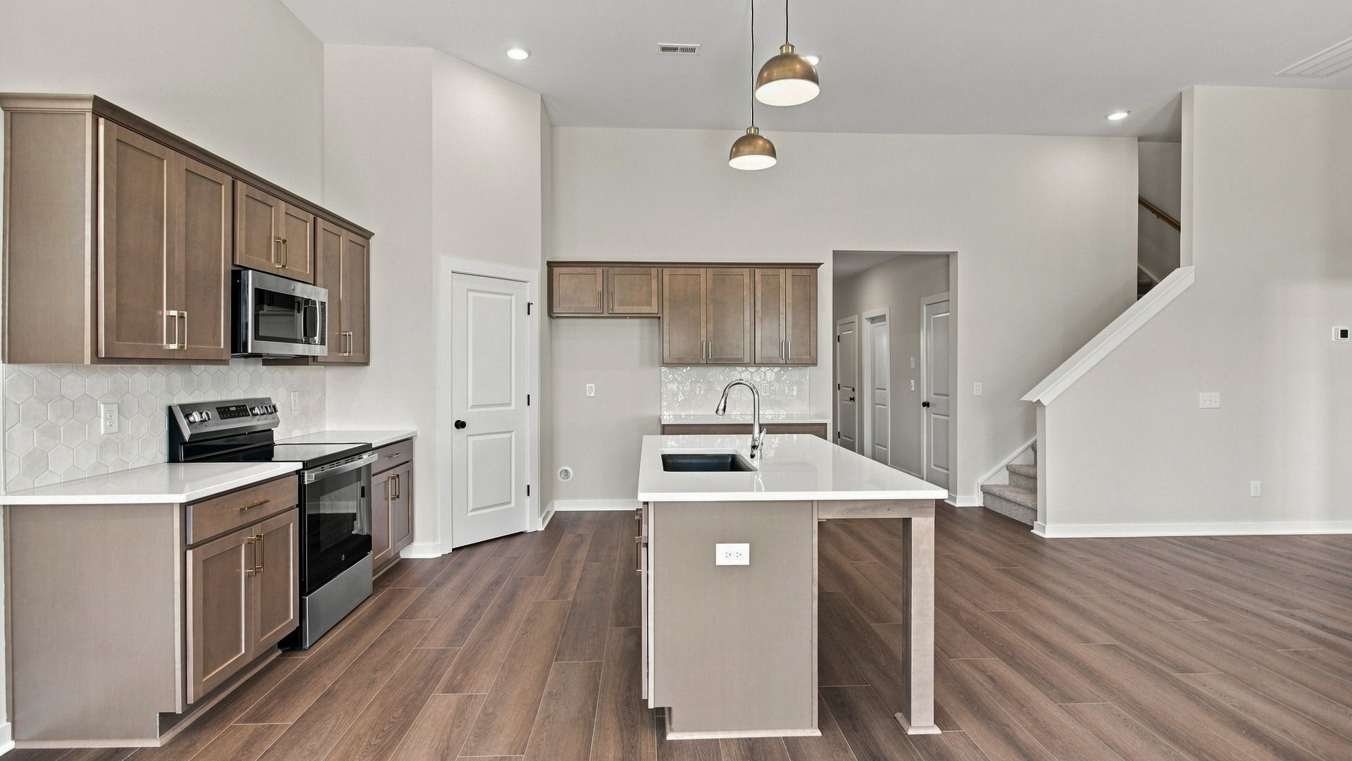 Kitchen with ceramic tile backsplash, quartz countertops, and stainless steel appliances