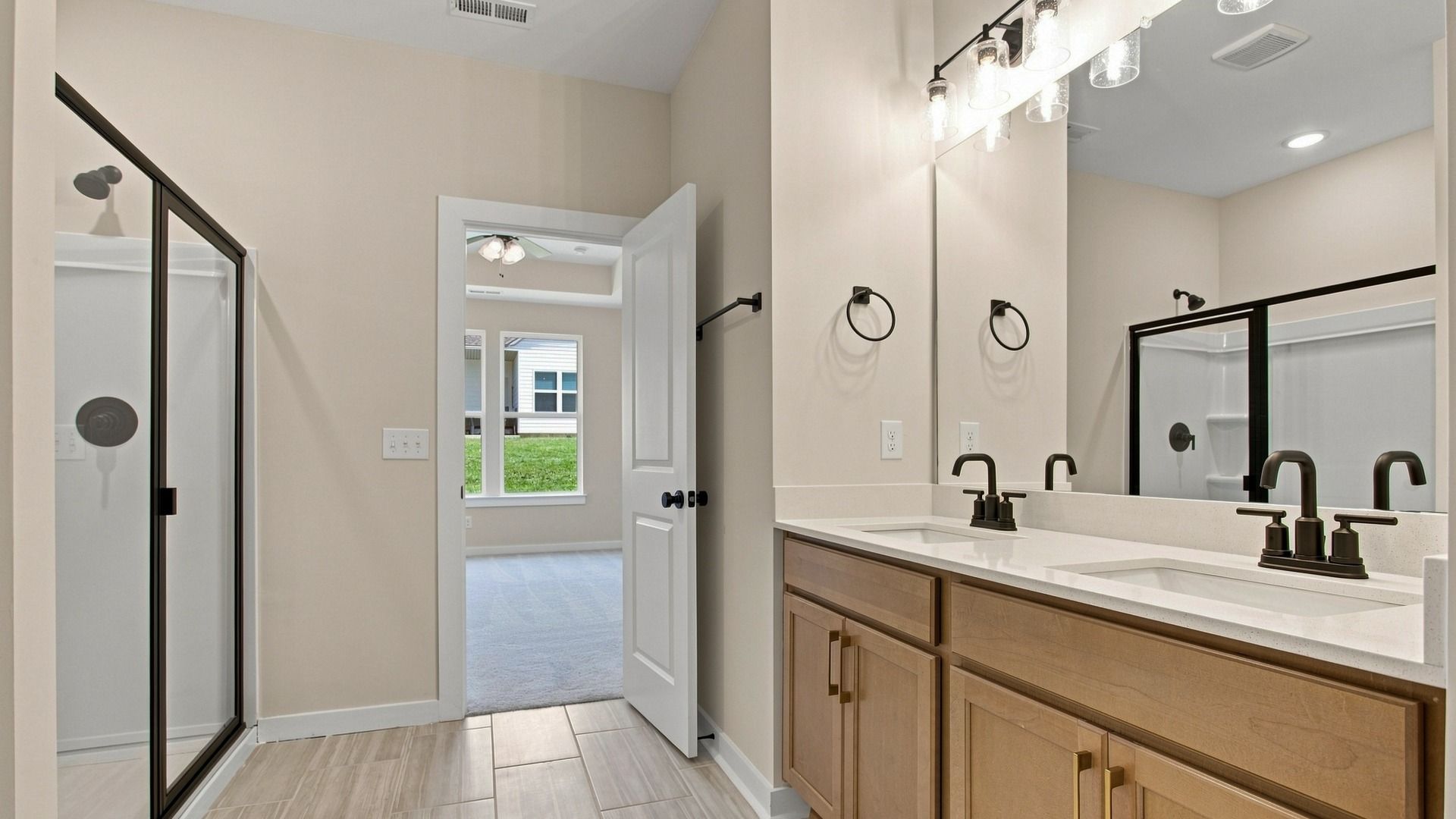 En-suite primary bathroom with dual sink vanity and walk-in shower