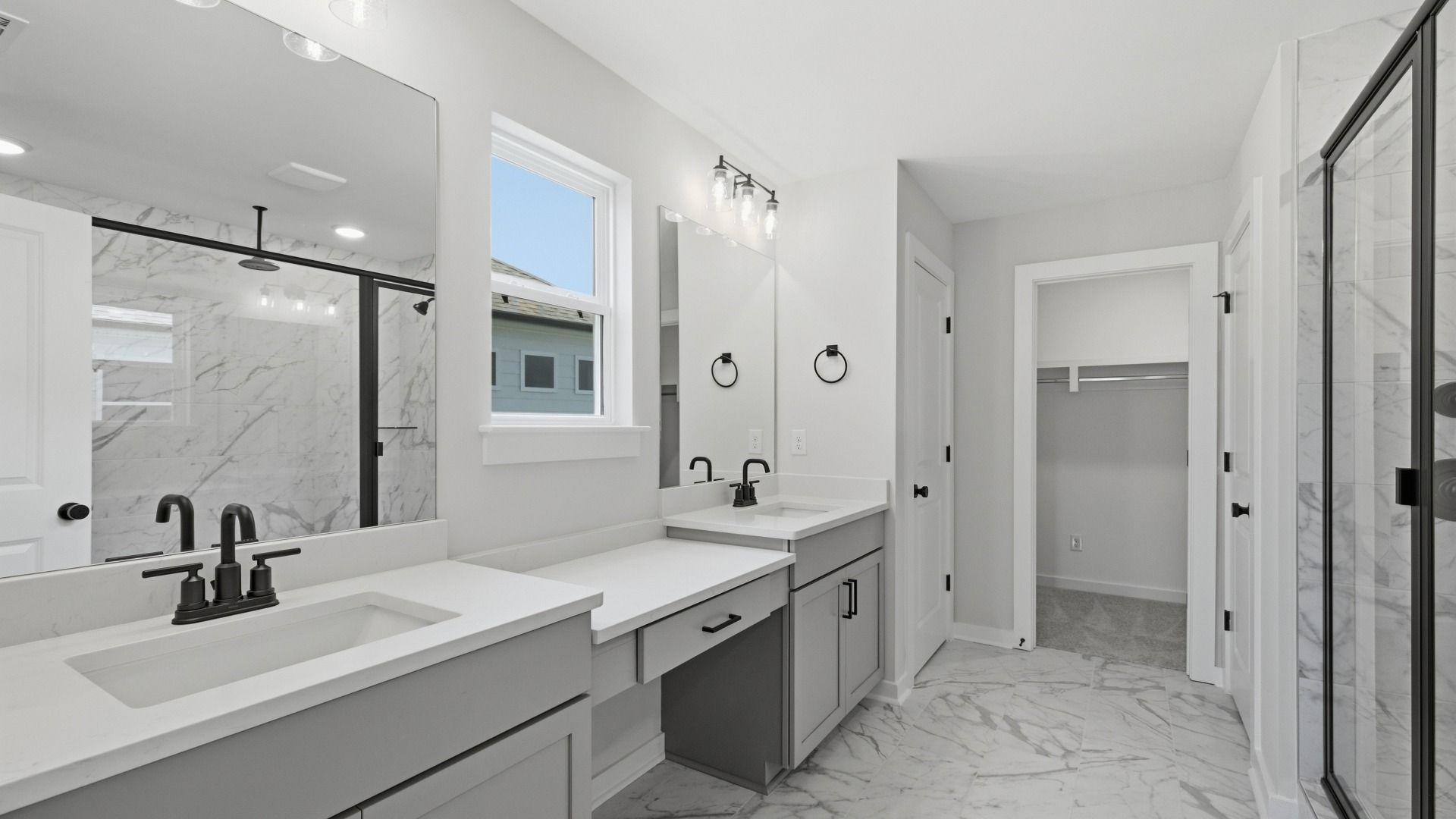 En-suite primary bathroom with dual vanity, tile flooring, and natural light