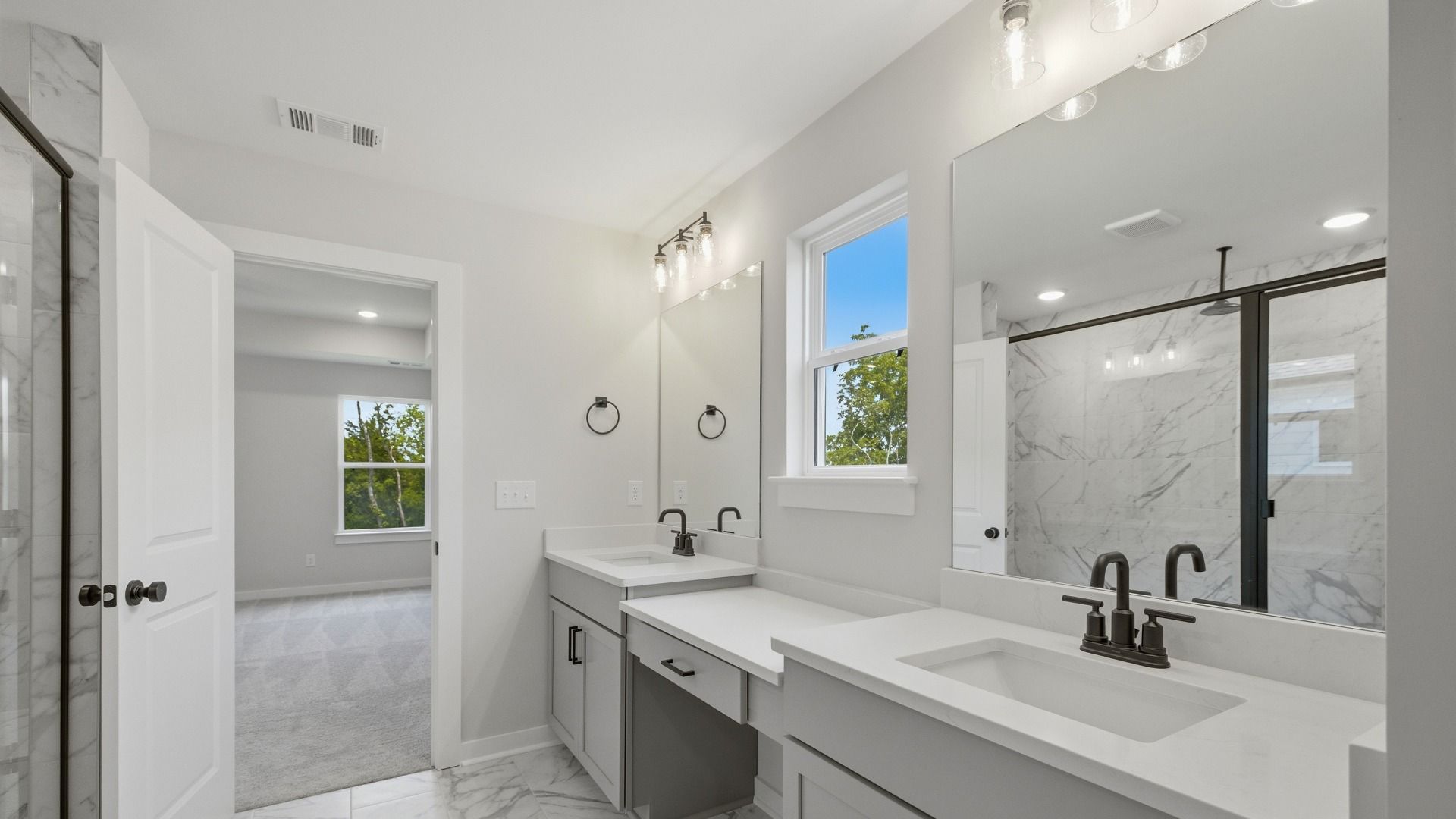En-suite primary bathroom with dual vanity, tile flooring, and natural light