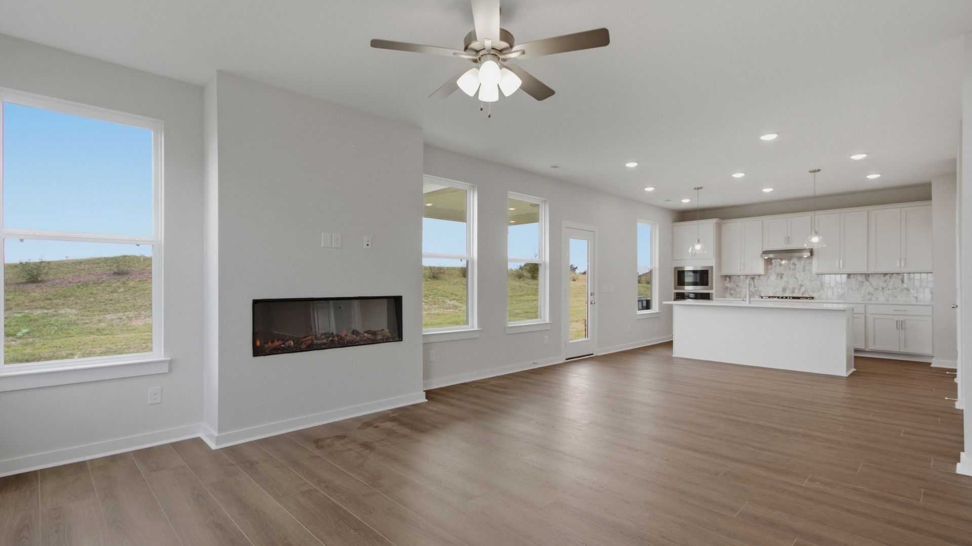 natural light fills the spacious living area next to the kitchen
