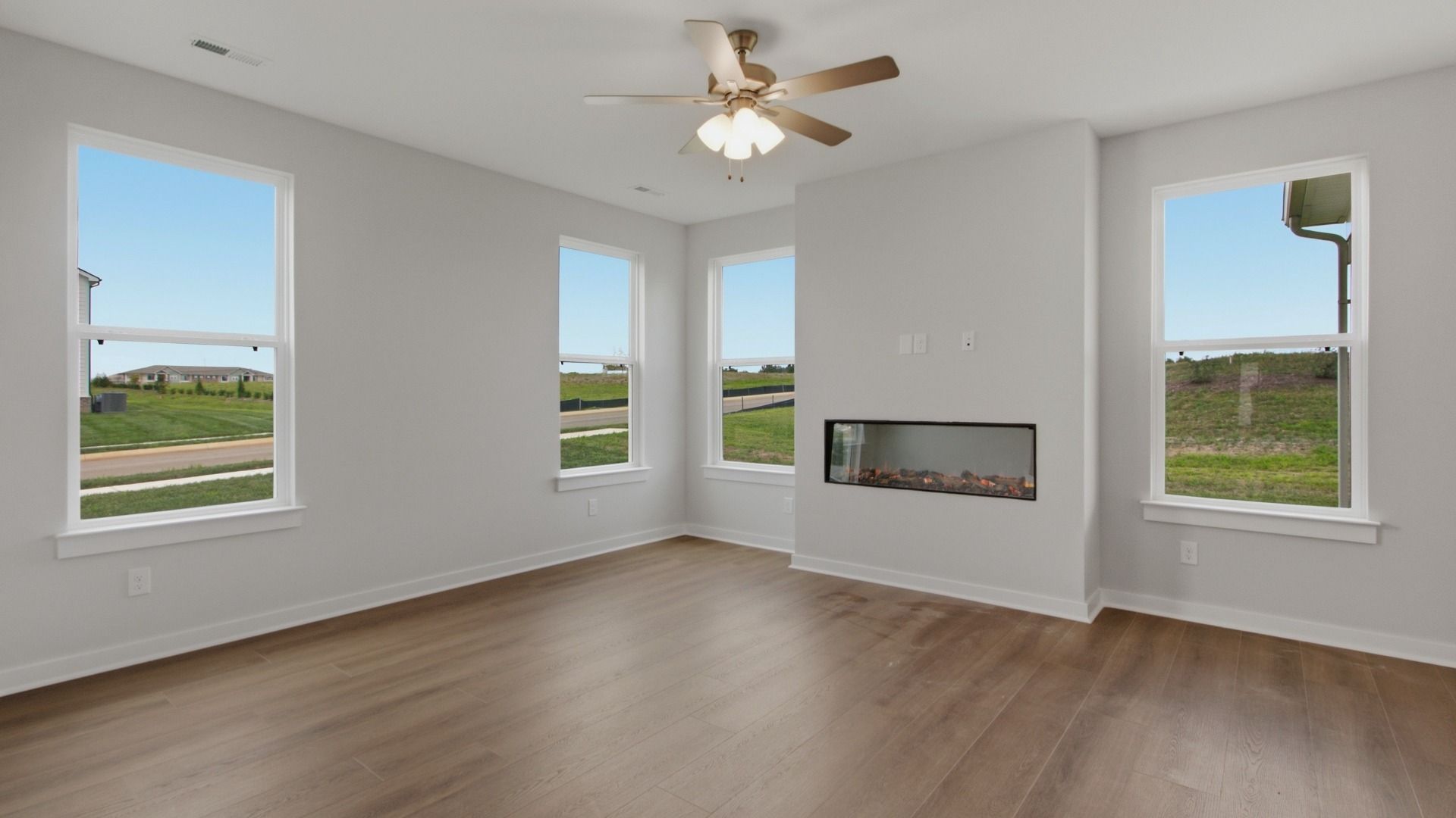 Spacious living area with ceiling fan and fireplace