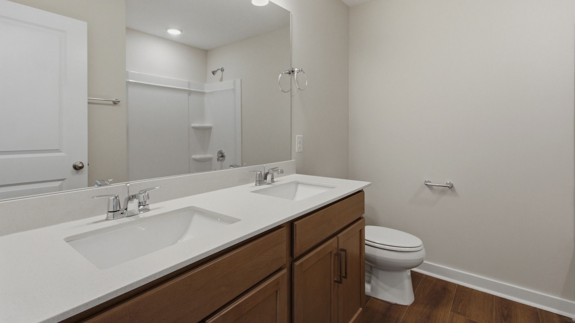 Secondary bathroom with large mirror and dual sinks