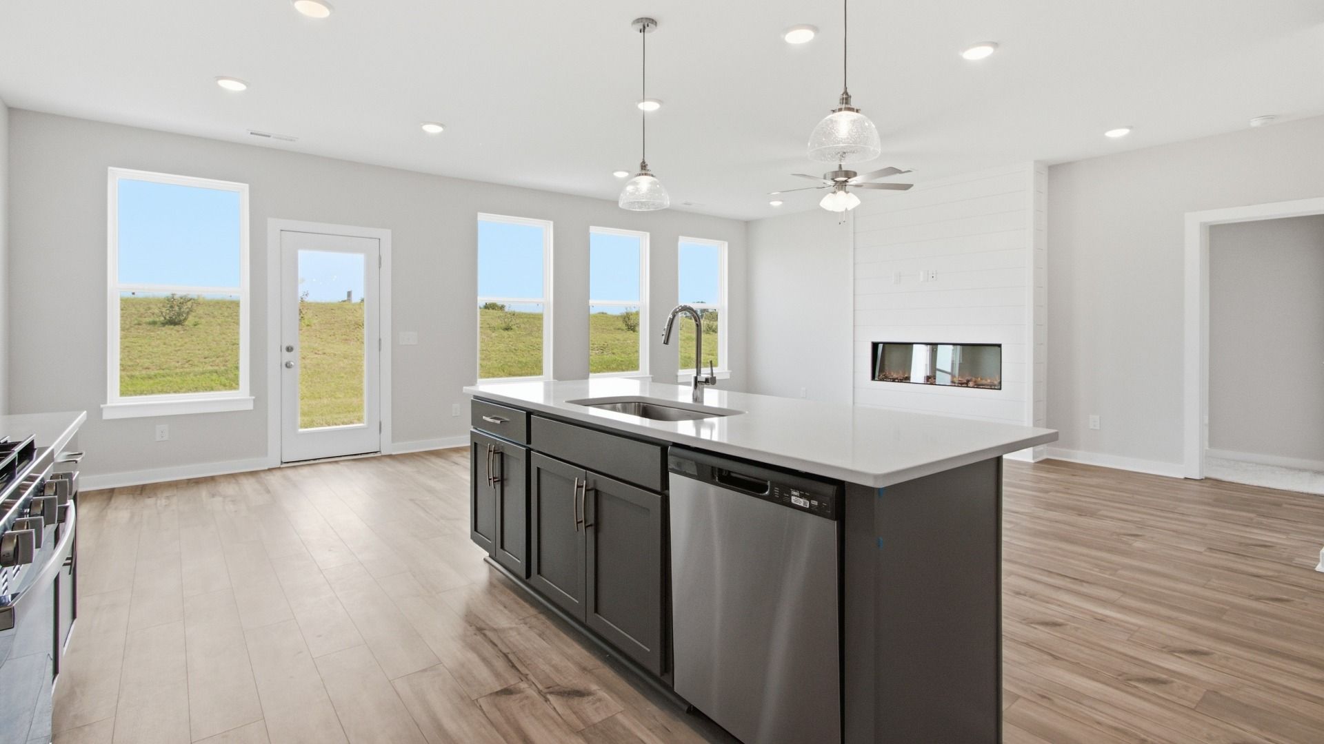 First floor layout with kitchen, dining area, and living room surrounded by windows