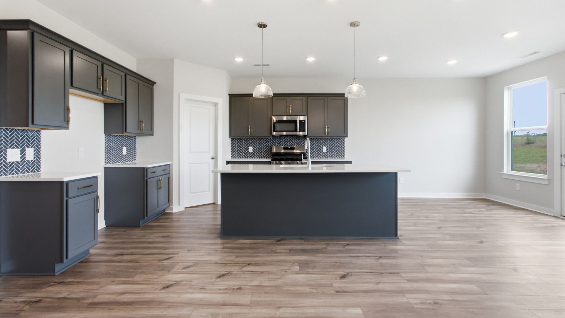 Kitchen with corner pantry and island, tile backsplash, and quartz countertops