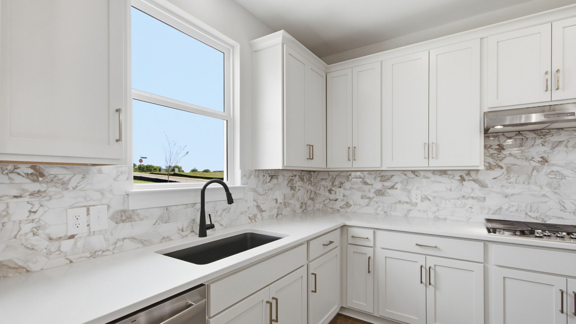 White kitchen cabinets with ceramic tile backsplash and quartz countertops