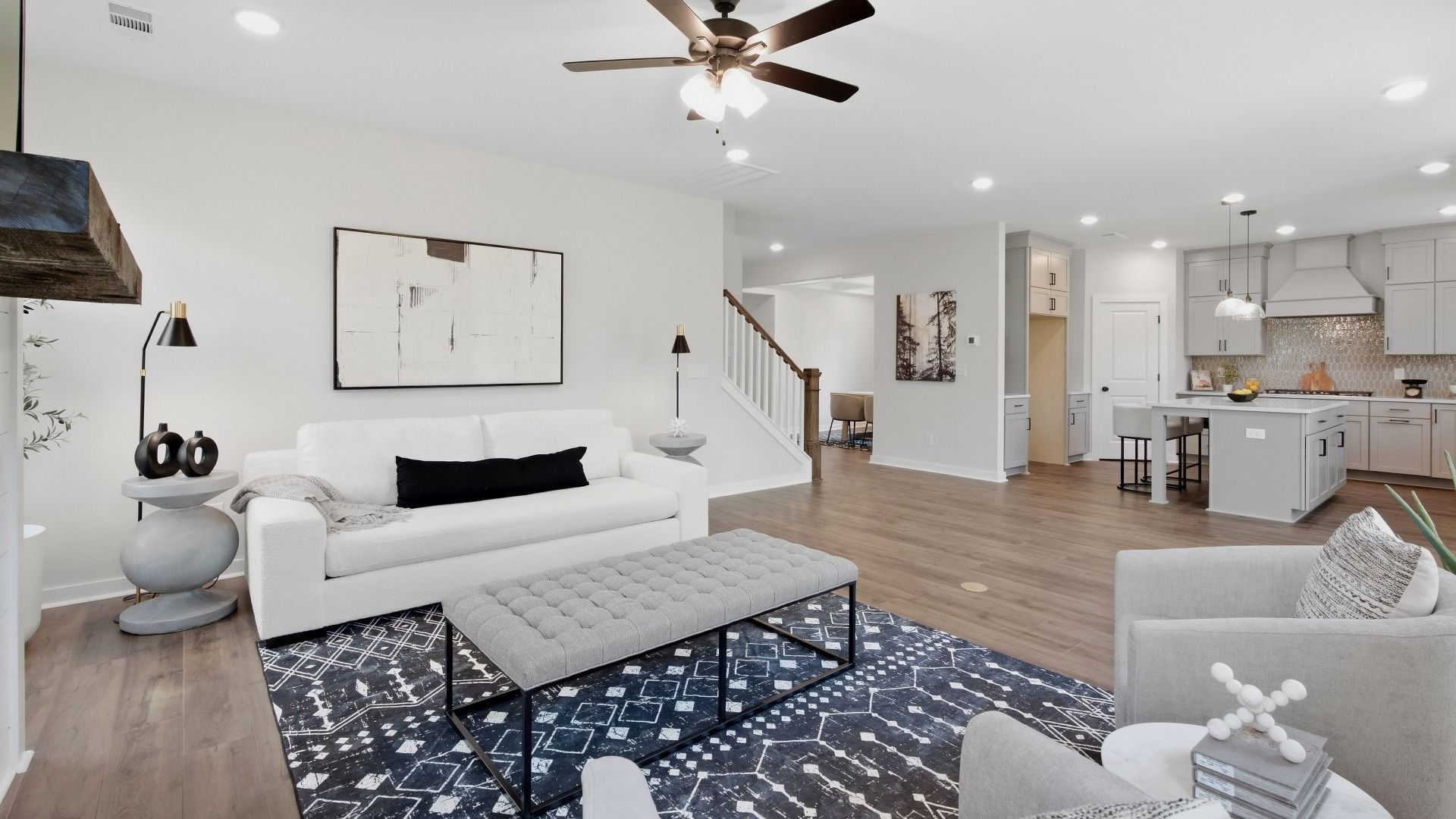 Elevated living area with kitchen, dining areas, and staircase close by