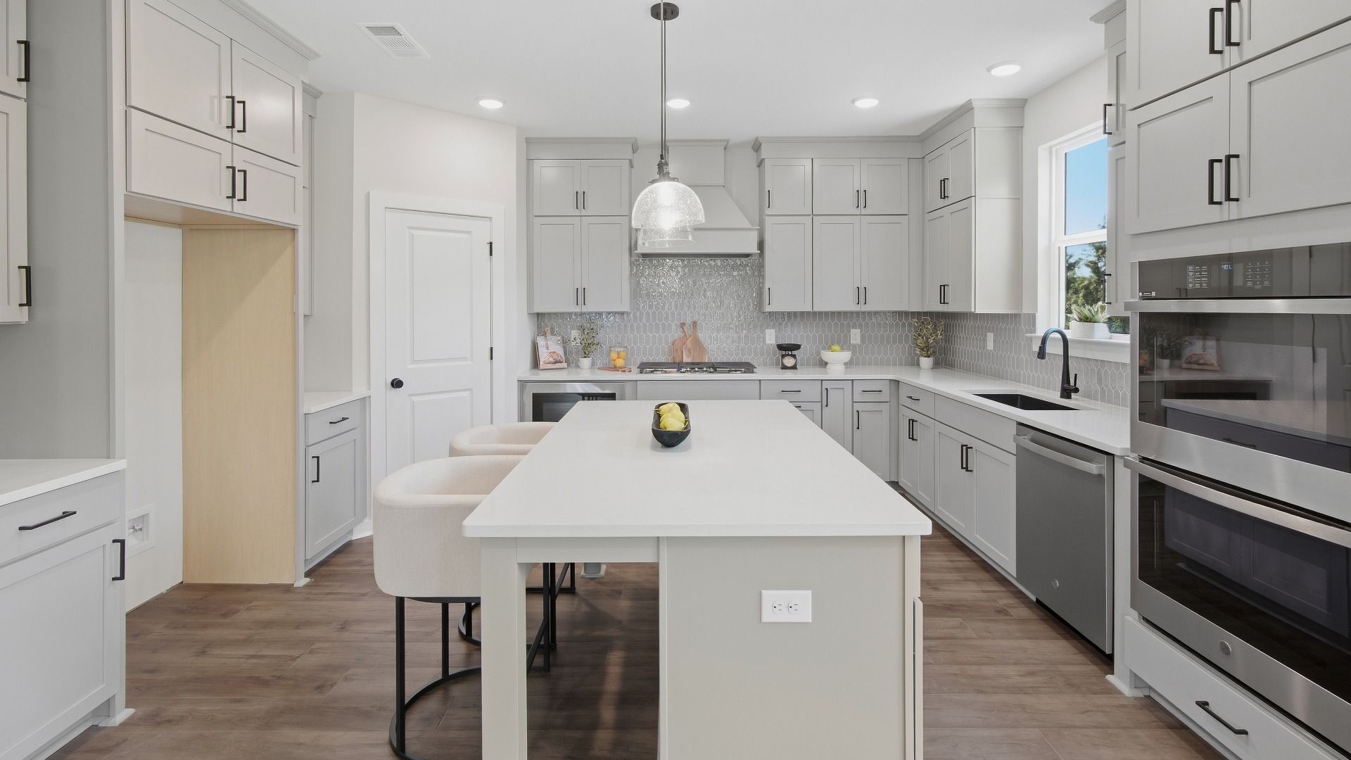 Kitchen with island and plenty of cabinets for convenient storage space next to pantry door