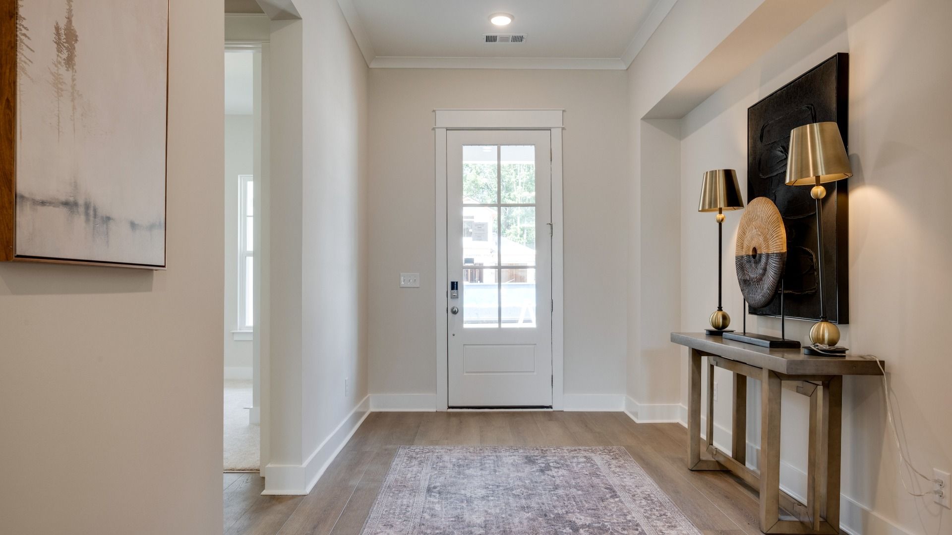 Front door leading into hallway with hardwood flooring