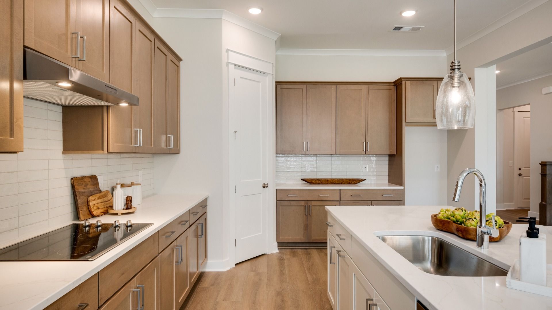 Sink and dishwasher paired with kitchen island next to staircase