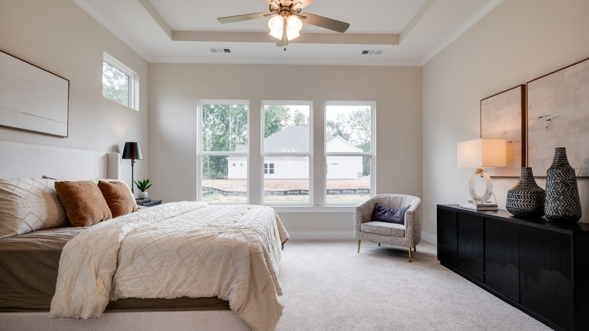 Primary bedroom with trey ceilings and sizeable windows connected to bathroom and walk-in closet