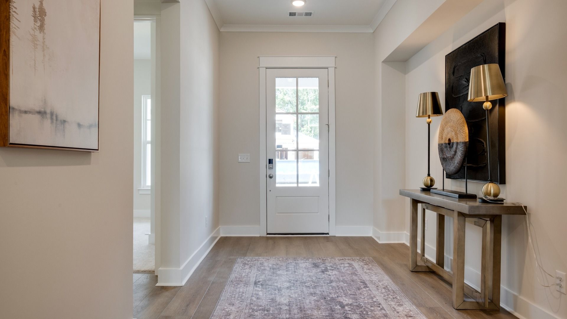 Front door leading into hallway with hardwood flooring