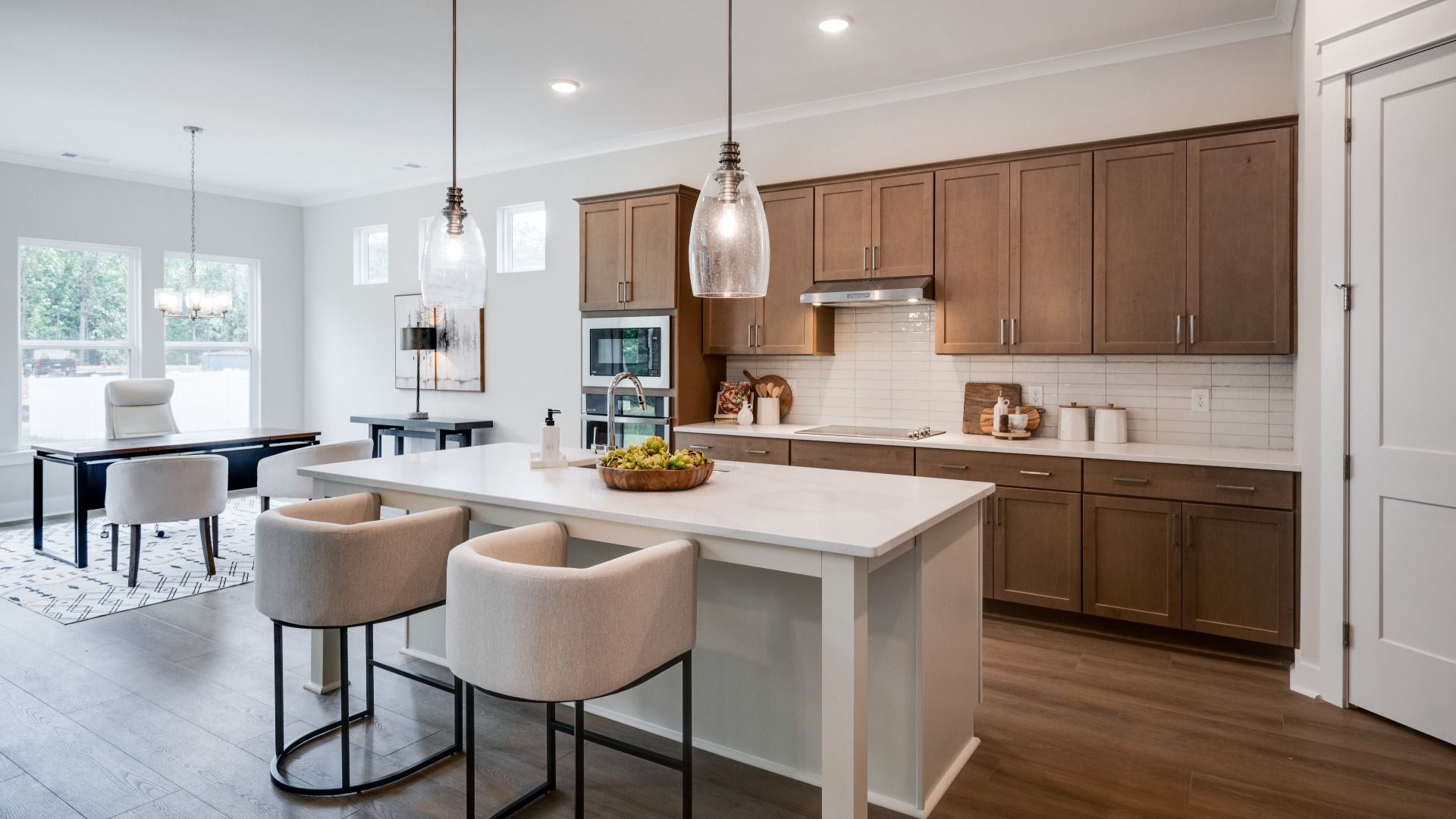 Hanging lights over kitchen island next to versatile living space