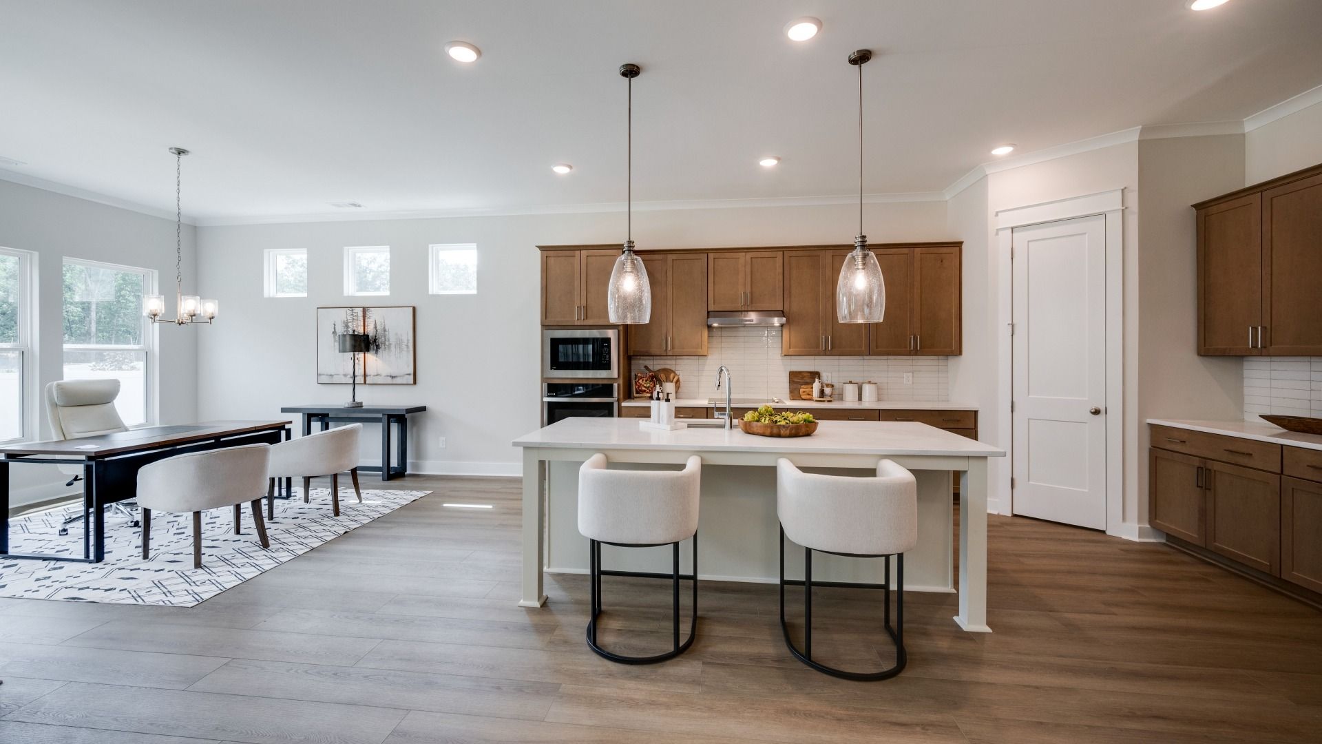 Hanging lights over kitchen island next to versatile living space