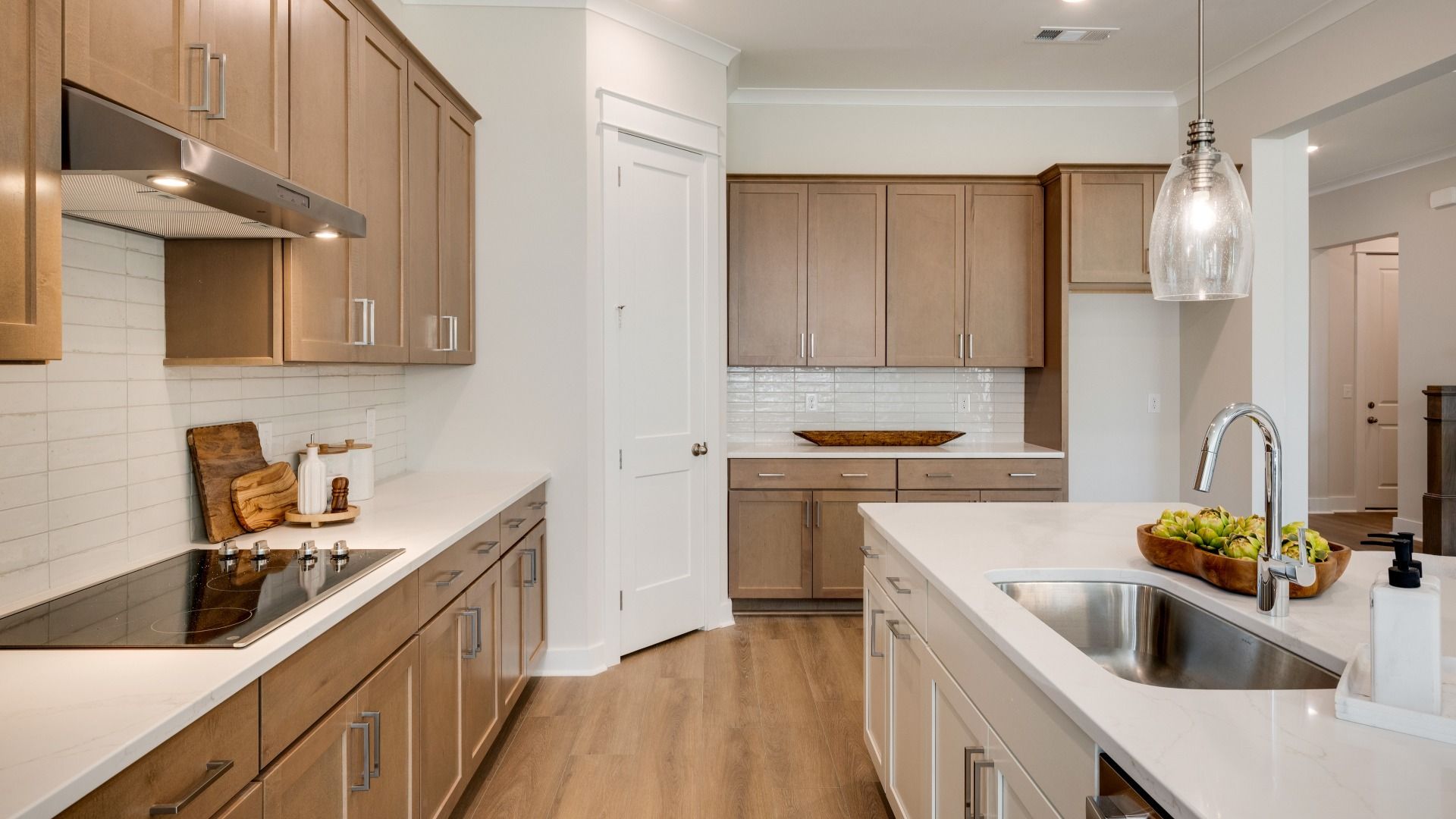 Sink and dishwasher paired with kitchen island next to staircase