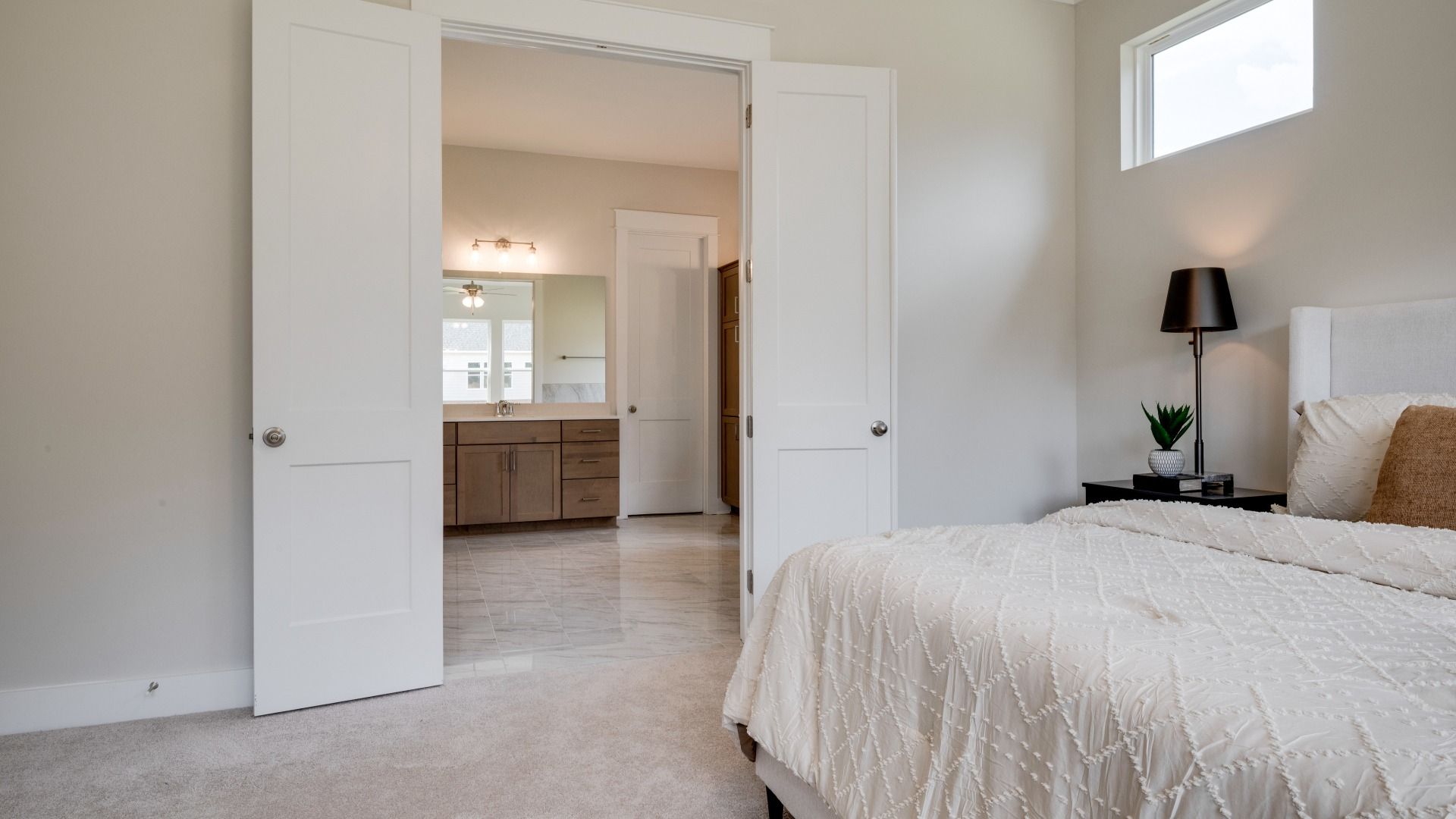 Primary bedroom with trey ceilings and sizeable windows connected to bathroom and walk-in closet